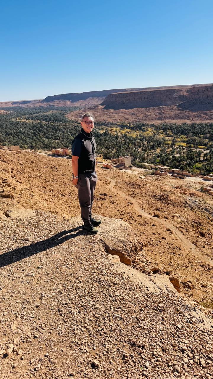 Una persona parada en una colina con vista a un pueblo.