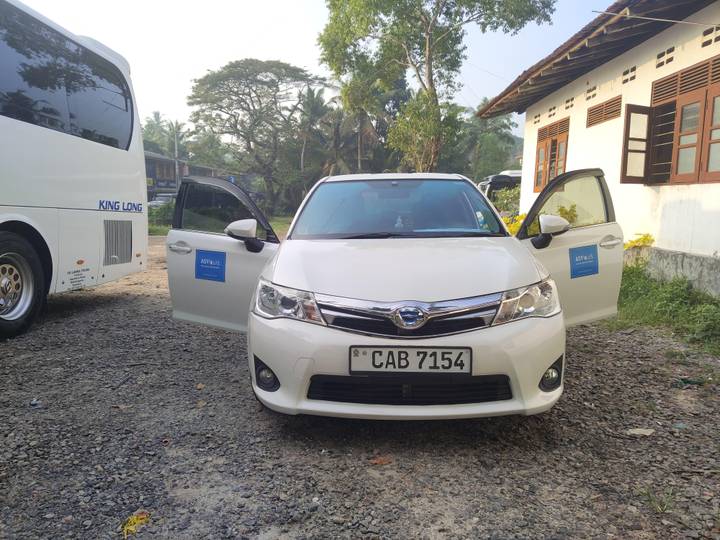 Geparktes Auto mit offenen Türen neben einem Bus.