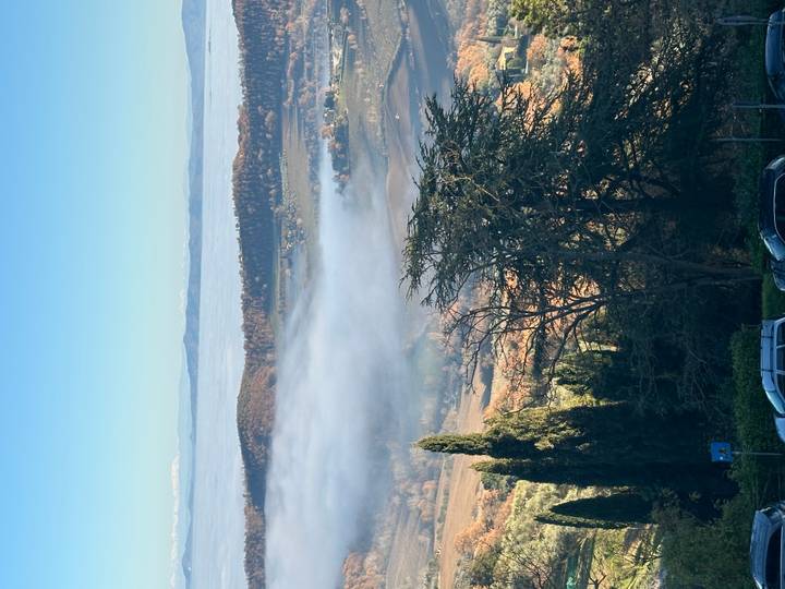 Vista panorámica de colinas con niebla y árboles distantes.