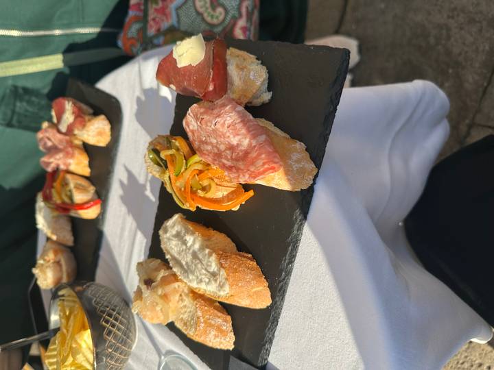 Varias bruschettas italianas en una bandeja al aire libre.
