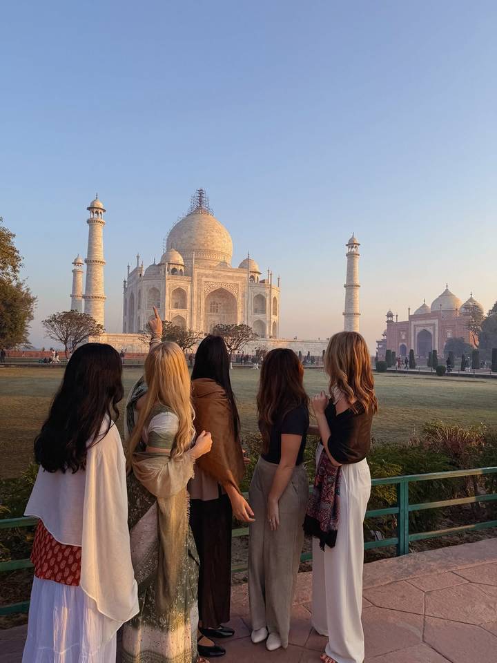 Groep mensen die de Taj Mahal op de achtergrond bewonderen.