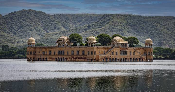 Jal Mahal, un palais situé au milieu d'un lac avec des collines environnantes.