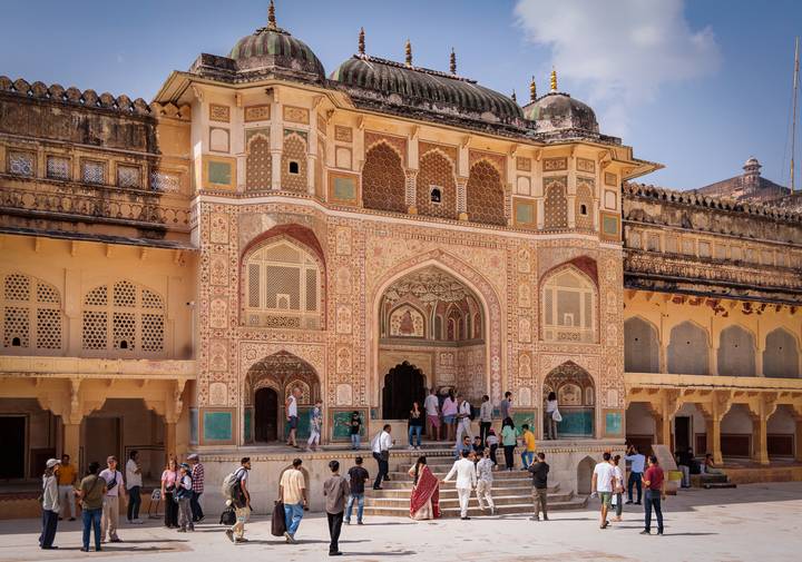 Entrée colorée et ornée du Fort d'Amber avec des personnes qui la traversent.