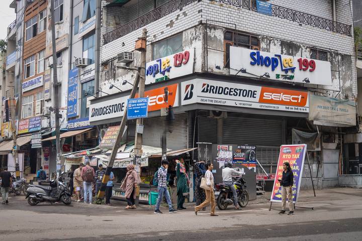 Scène de rue animée présentant un coin avec plusieurs magasins et enseignes.