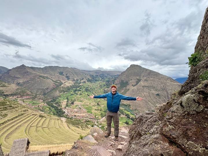 Person posing with arms outstretched on a mountain in Peru.
