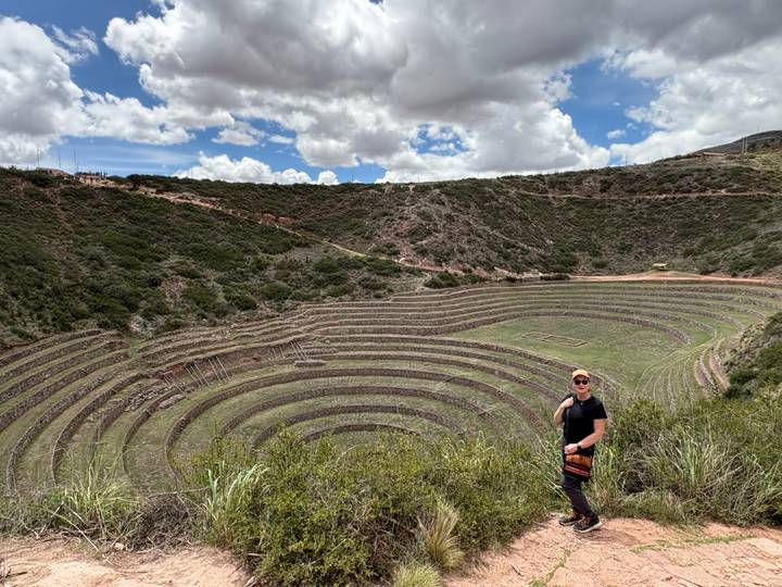 Person posing in front of circular terraces at Moray.