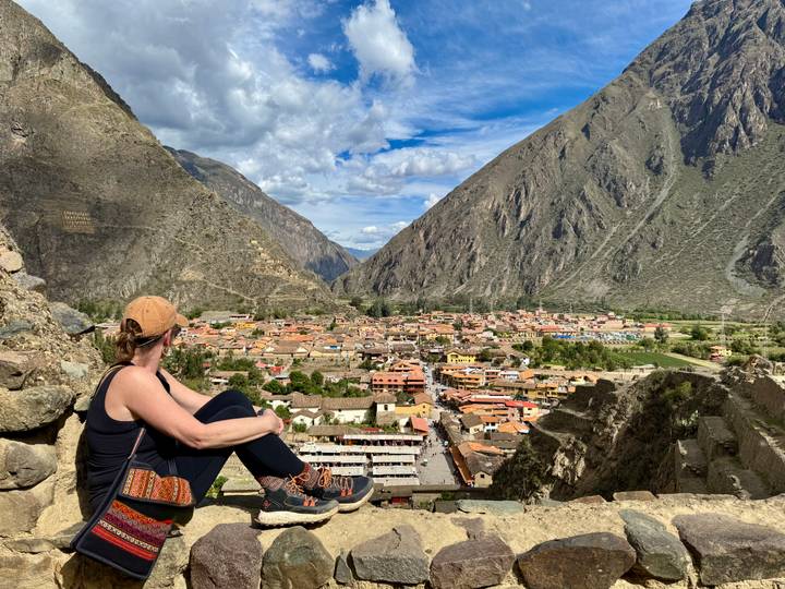 Person sitting on a hill overlooking Ollantaytambo.