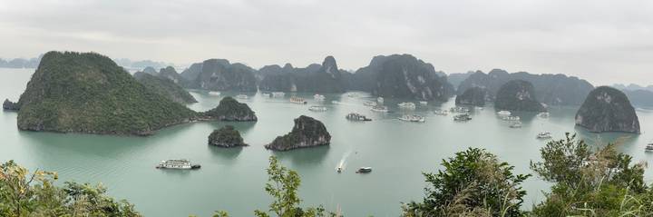 Vista panorámica de la Bahía de Halong con barcos y formaciones kársticas.
