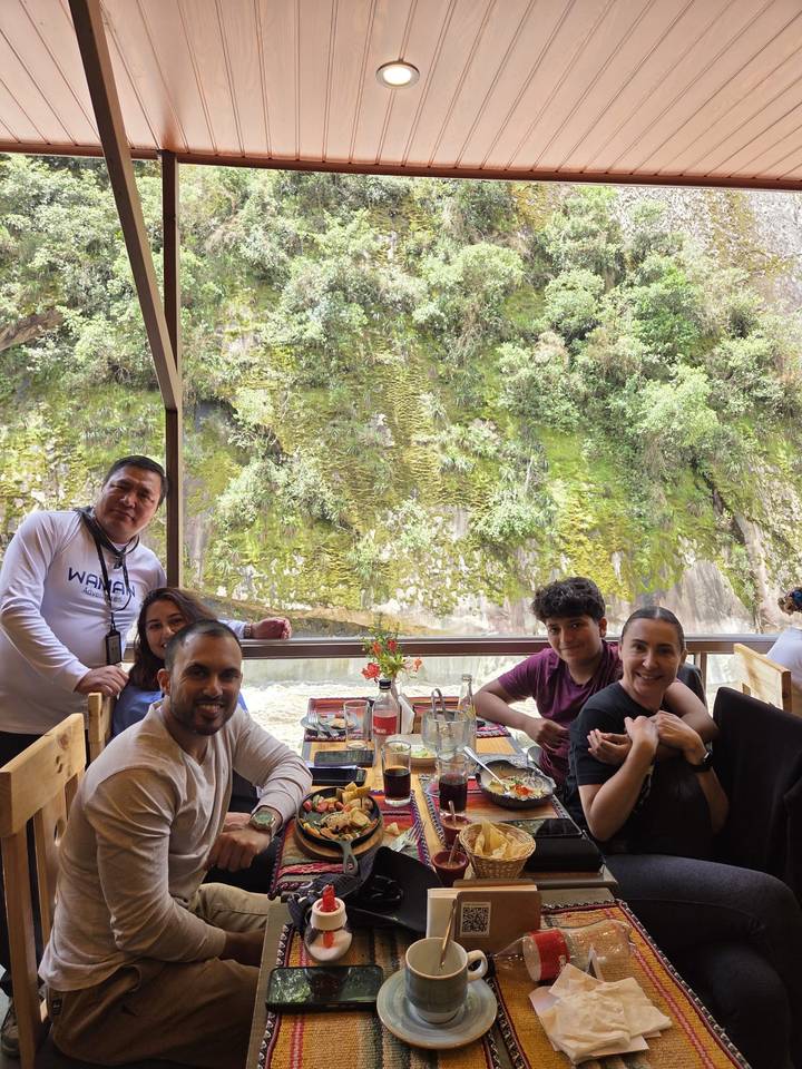 A group of people dining with a scenic view outside.