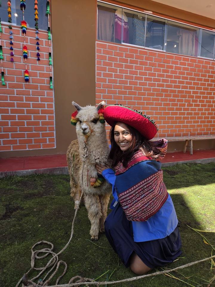 Woman posing with an alpaca.