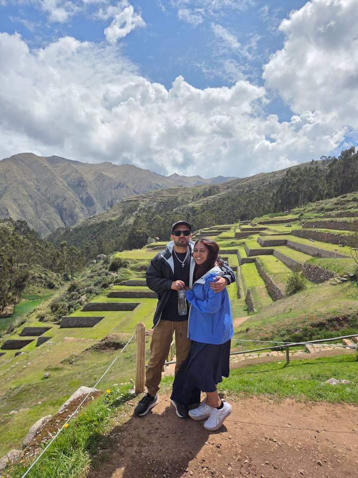 Couple posing with a scenic terrace field in the background.