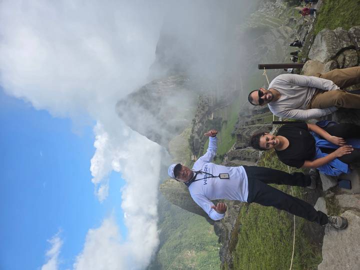 Tourists at Machu Picchu with mist and mountains.