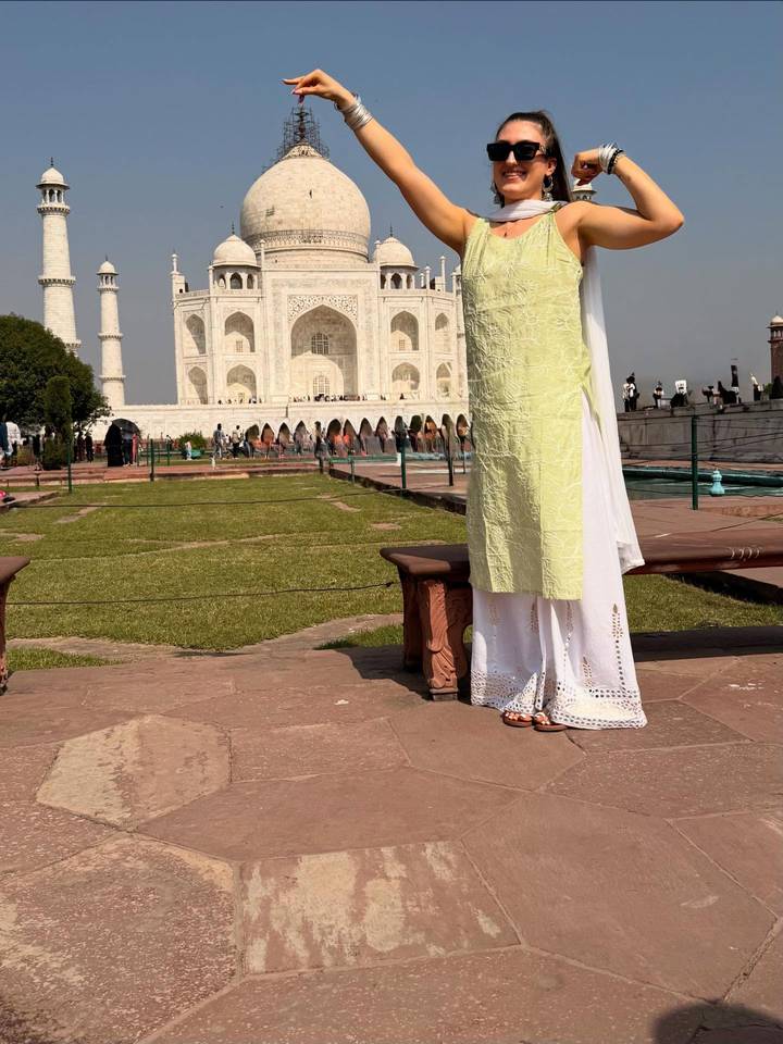 Vue partielle d'une personne devant le Taj Mahal, se concentrant sur la tenue vestimentaire.