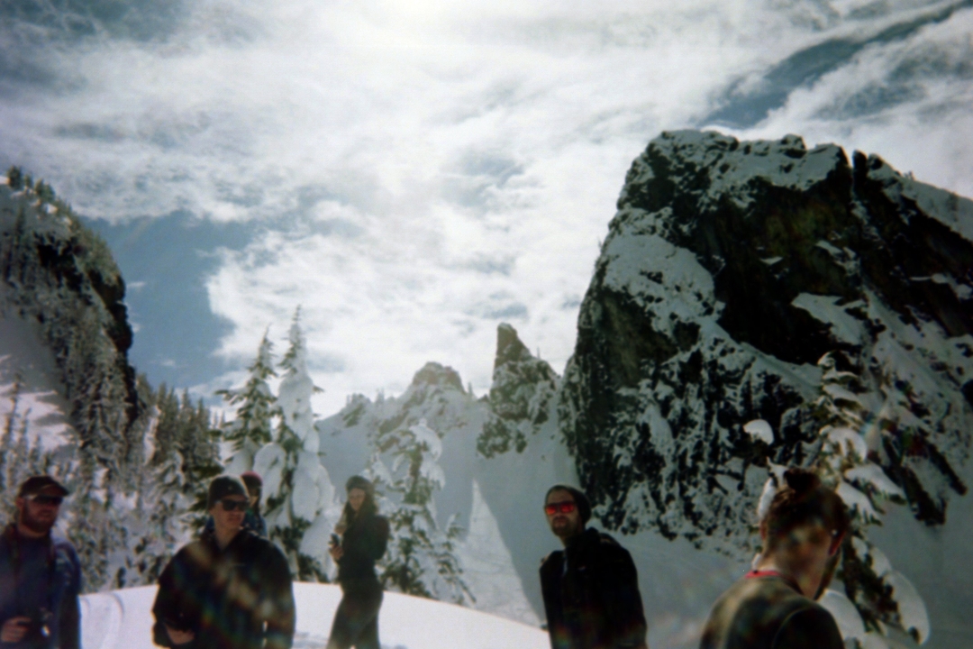 Groupe de personnes debout dans un paysage de montagne enneigée.