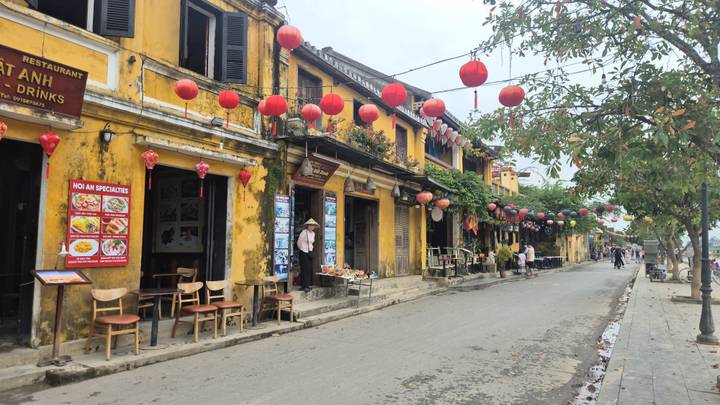 Vista de calle en Hoi An con arquitectura tradicional y linternas rojas.