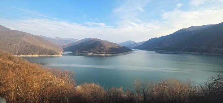 Lago tranquilo rodeado de montañas.