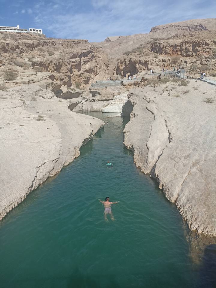 Des gens qui nagent dans un canyon étroit avec une eau claire.