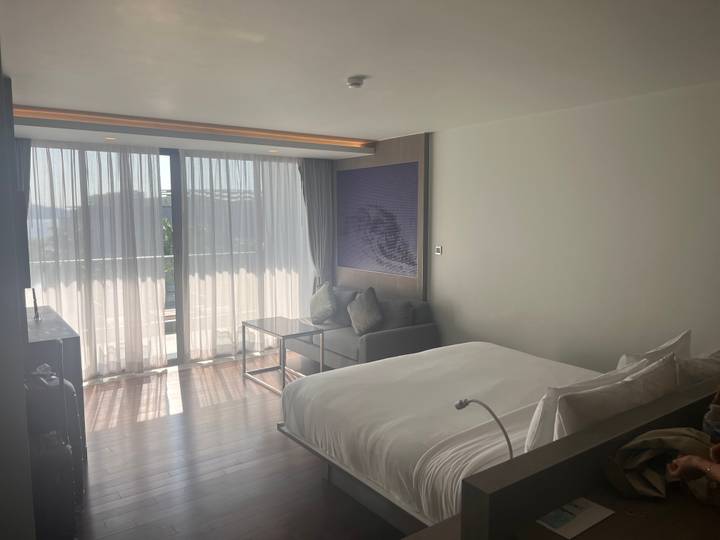 Chambre d'hôtel avec un grand lit et vue sur fenêtre.