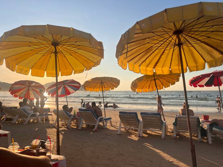 Parasols de plage avec des gens qui se détendent au bord de l'océan.