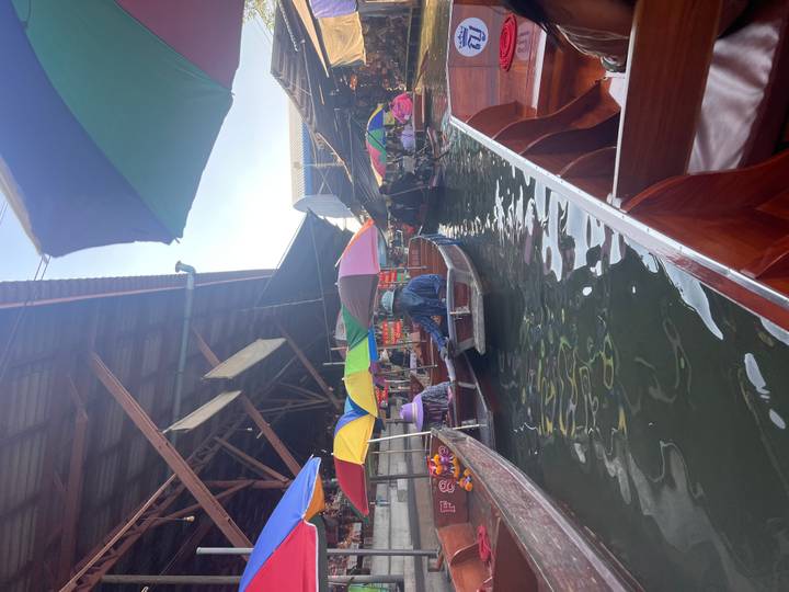 Marchés flottants avec des parasols colorés sur les bateaux.