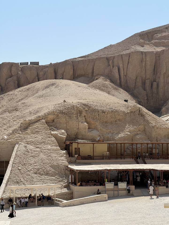 Visiteurs sur un site de temple ou de tombeau rocheux.