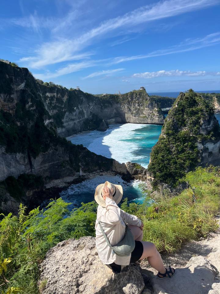 Personne profitant d'une vue à couper le souffle sur une falaise côtière et l'océan.