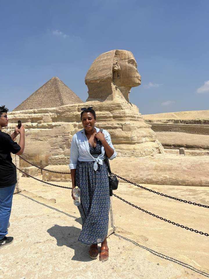 Personne posant avec le Sphinx et les pyramides en arrière-plan.
