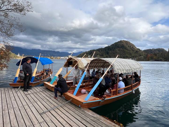 Turistas en botes tradicionales de madera en un lago.