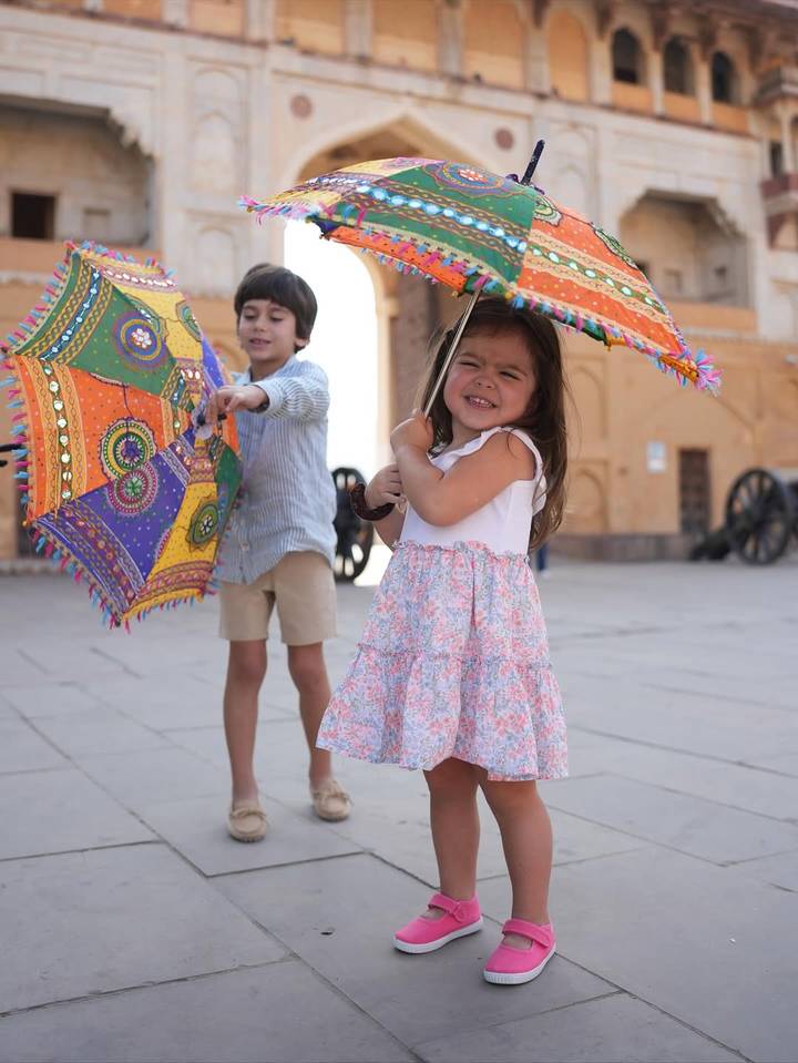 Des enfants jouant avec des parapluies colorés.