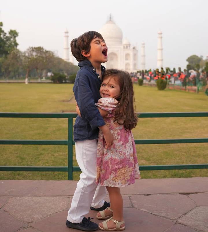 Enfants qui s'embrassent avec le Taj Mahal en arrière-plan.