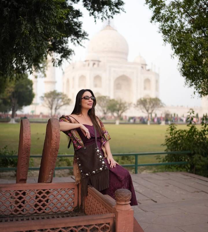 Femme posant avec le Taj Mahal en arrière-plan.