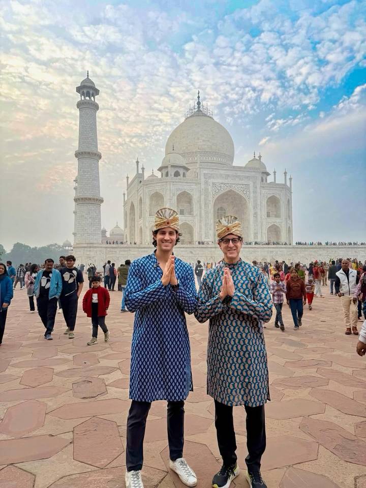 Deux hommes en tenue traditionnelle avec le Taj Mahal en arrière-plan.