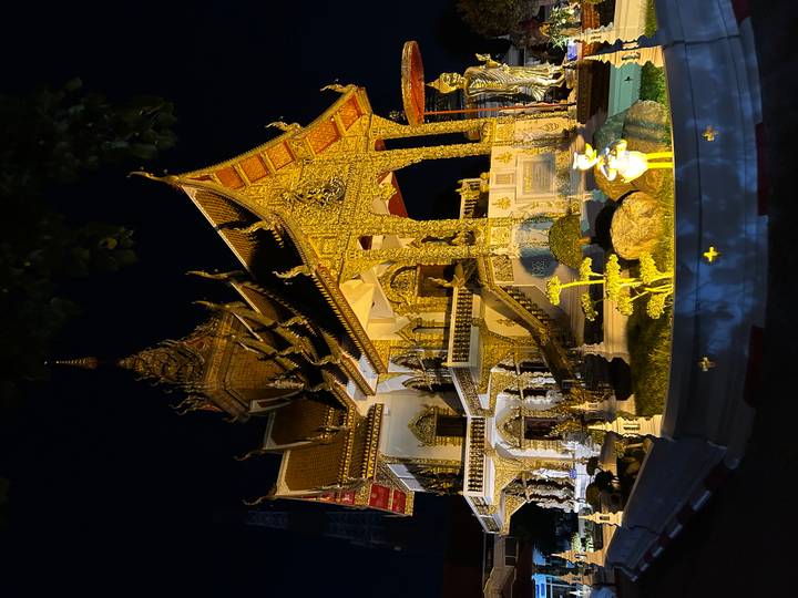 Templo ornamentado iluminado por la noche con arquitectura intrincada.