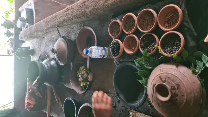 Configuración de cocina tradicional con ollas de barro e ingredientes.