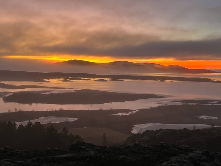 Coucher de soleil sur une étendue d'eau parsemée d'îles avec des nuages spectaculaires.