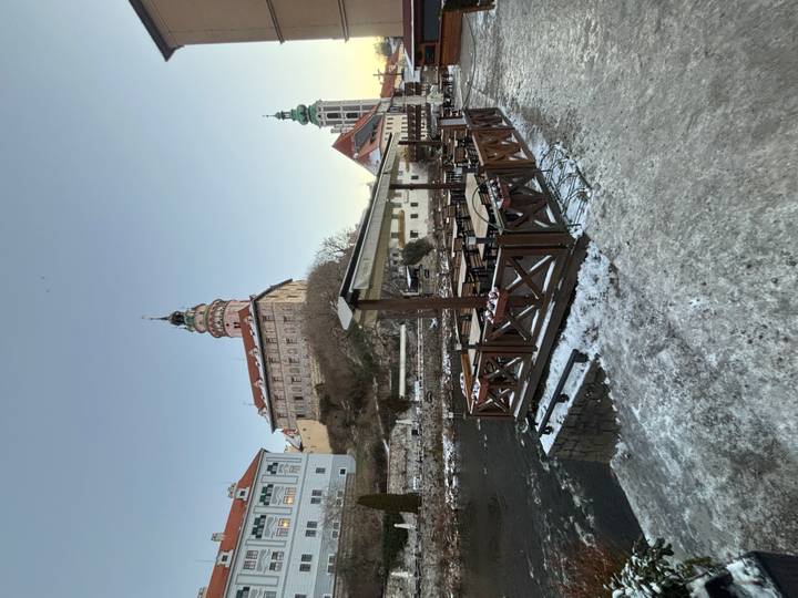 Vista de un Cesky Krumlov nevado con un castillo.