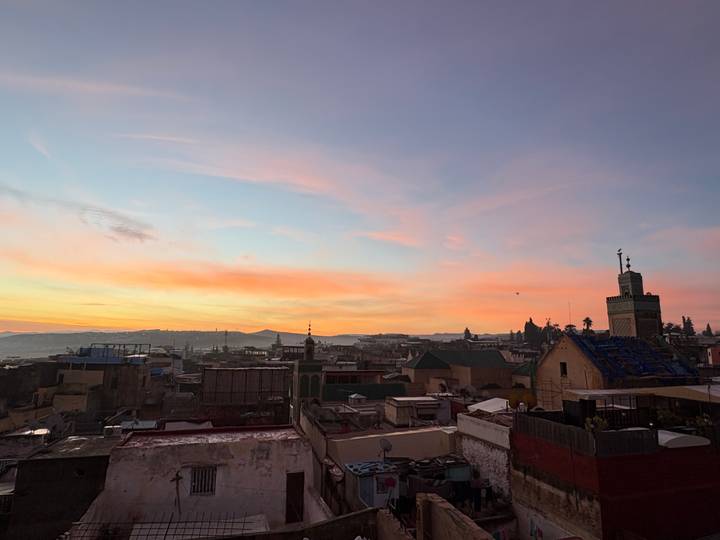 Skyline of a city at sunset with rooftops