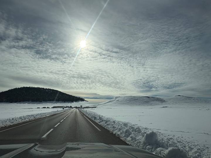 Snow-covered landscape with the sun in the sky