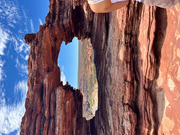 Rock arch with a view over a desert landscape.