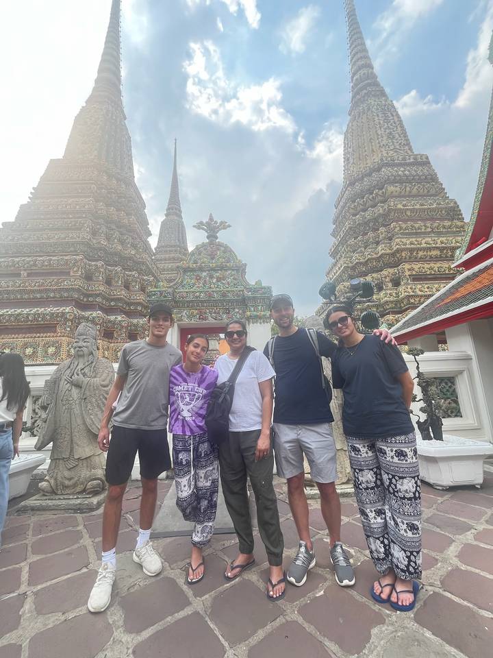 Grupo de personas posando frente a estructuras de templos intrincadamente decoradas.