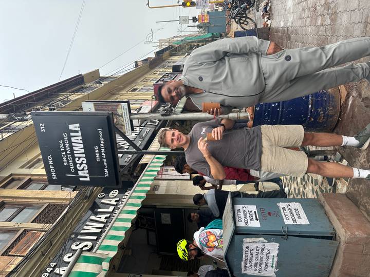Dos personas disfrutando bebidas afuera de una tienda famosa.