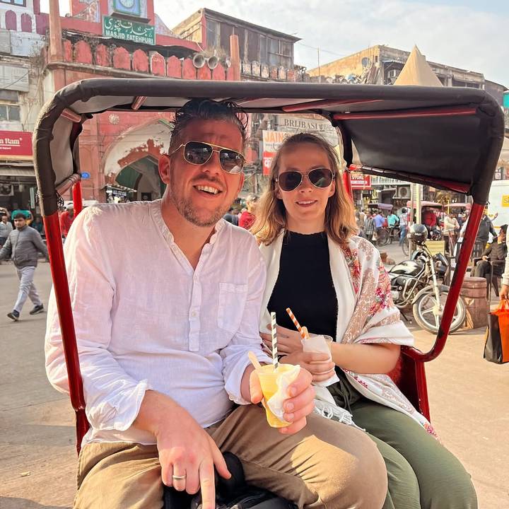 Deux touristes savourant des boissons pendant qu'ils se font transporter en pousse-pousse.