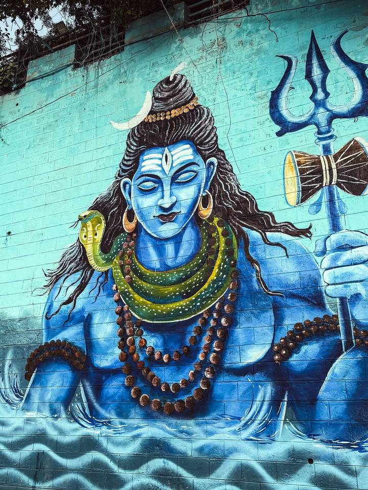 Peinture murale représentant le dieu hindou Shiva avec une expression sereine.