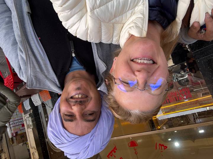 Deux personnes prenant un selfie dans un environnement de rue.