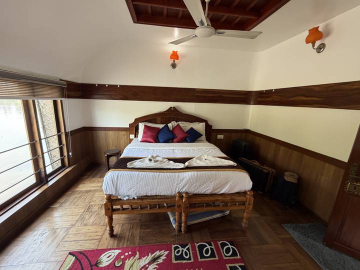 Intérieur de chambre à coucher avec un lit soigneusement fait et une décoration en bois.