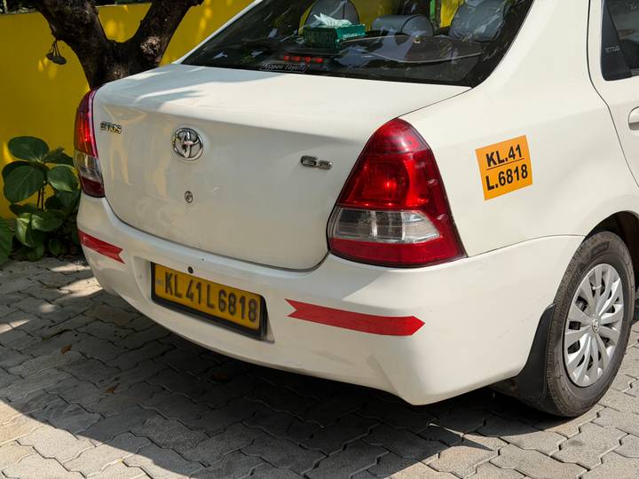 Vue arrière d'une voiture blanche avec une plaque jaune.