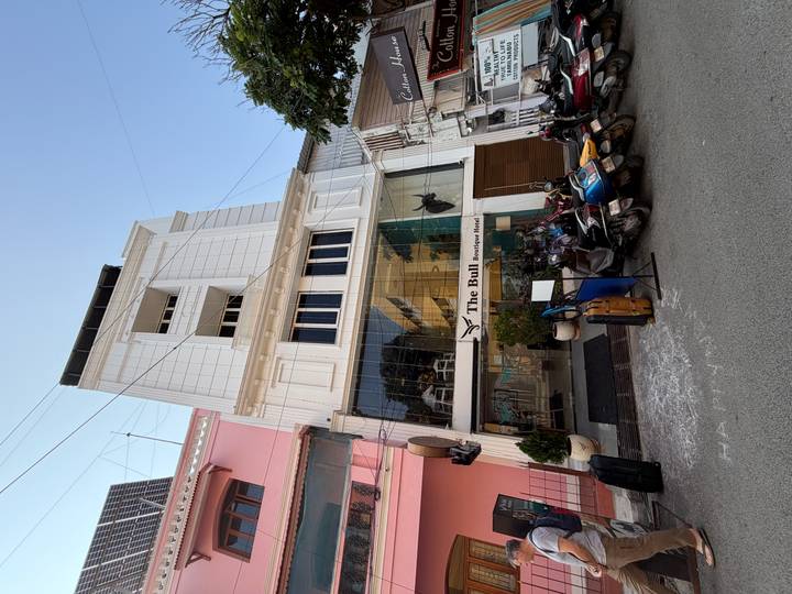 Vue de face d'un hôtel boutique avec des véhicules stationnés.
