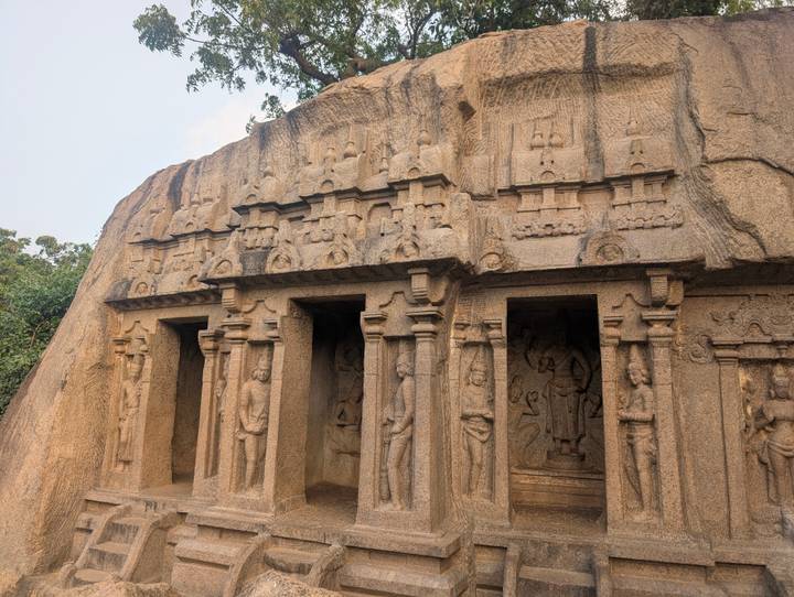 Vue détaillée de sculptures de temple antique dans un mur de pierre.