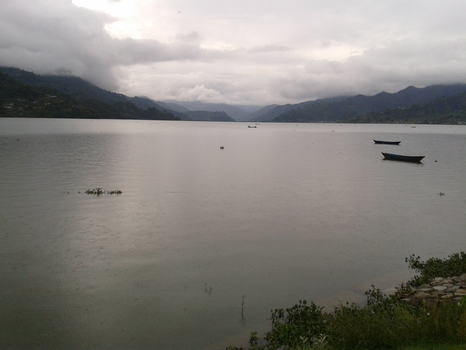 Lac calme avec des montagnes et un ciel nuageux.