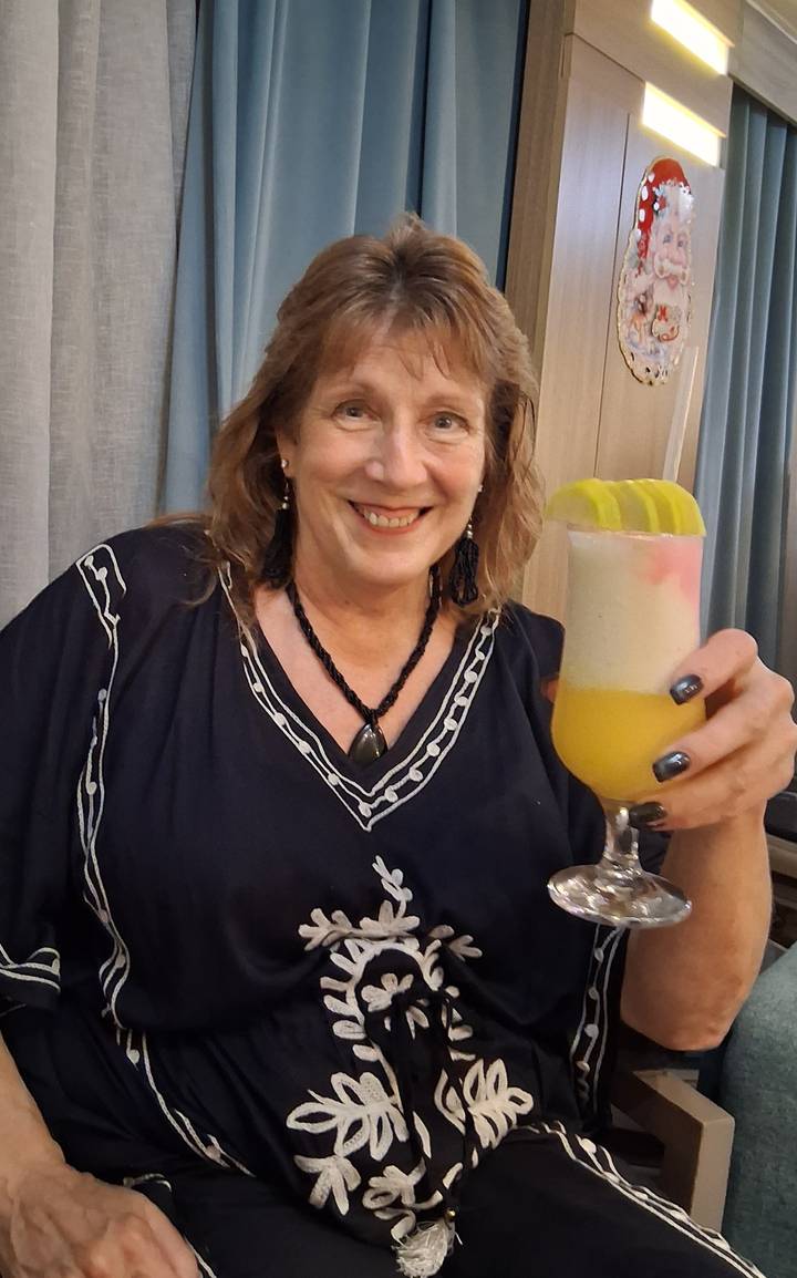 Person holding a colorful tropical drink.